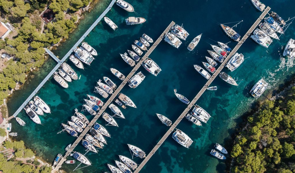 Private yacht anchored in a peaceful Adriatic bay in Croatia, reflecting a relaxed and transparent charter experience